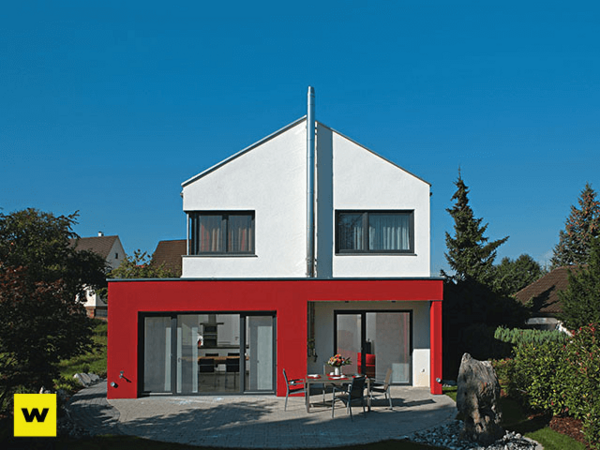 Modernes Einfamilienhaus mit Flachdach, roter Fassade und großen Fenstern im Garten.